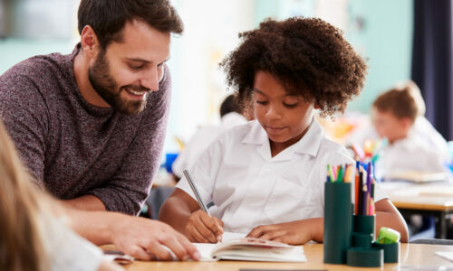 Male tutor helping young girl